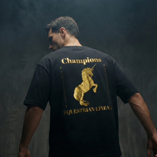 Model wearing black oversized tee with gold horse design on back.