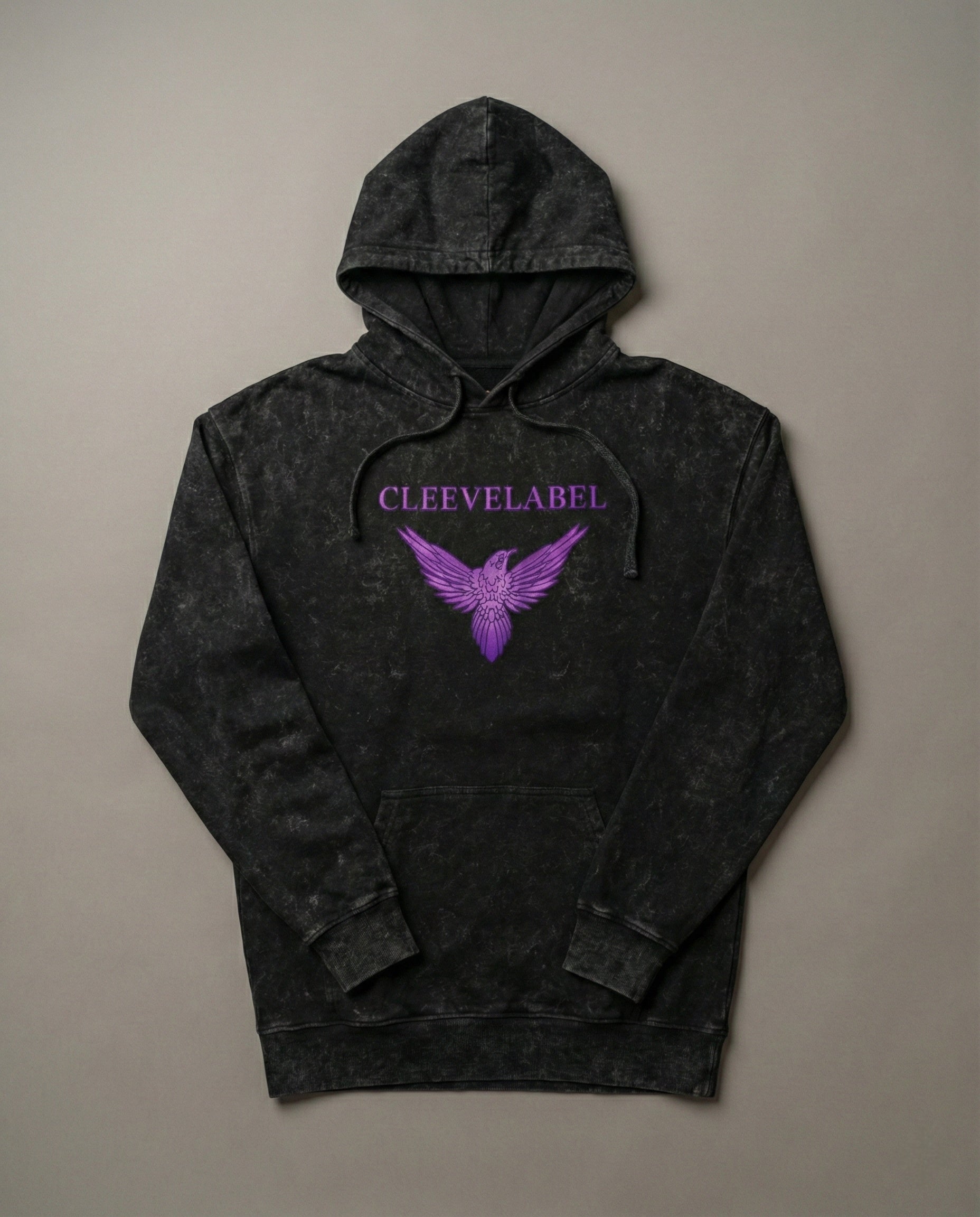 Black acid-wash hoodie laid flat on neutral background with Cleevelabel logo and purple wing graphic on front.