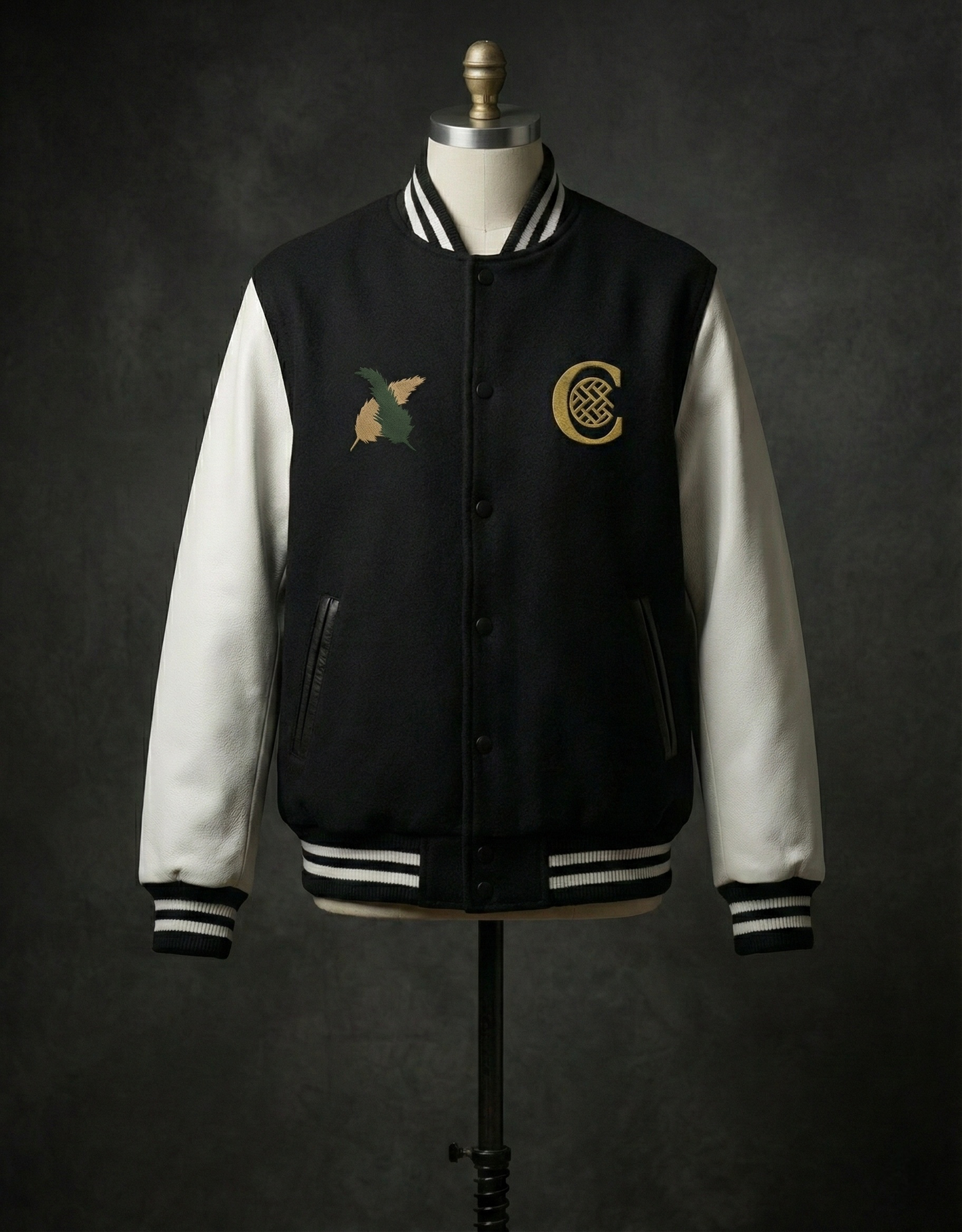 Black and white varsity jacket on mannequin with front logos.